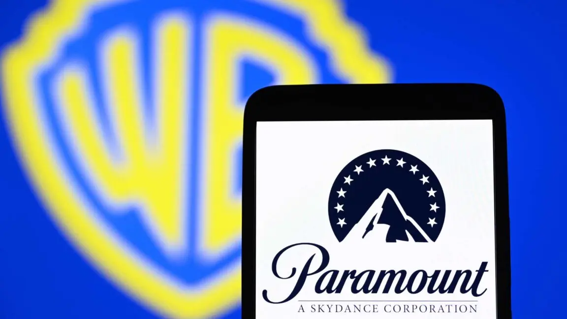Paramount's logo displayed on a smartphone in front of a backdrop with the Warner Bros. logo