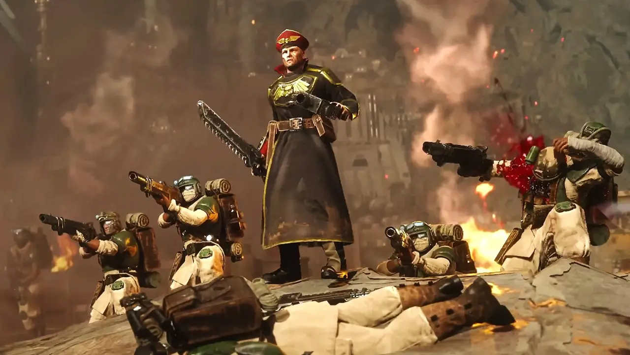 A commander in a long black coat and red cap stands among soldiers in green and tan armor, firing rifles amidst smoke and fire on a rocky battlefield.