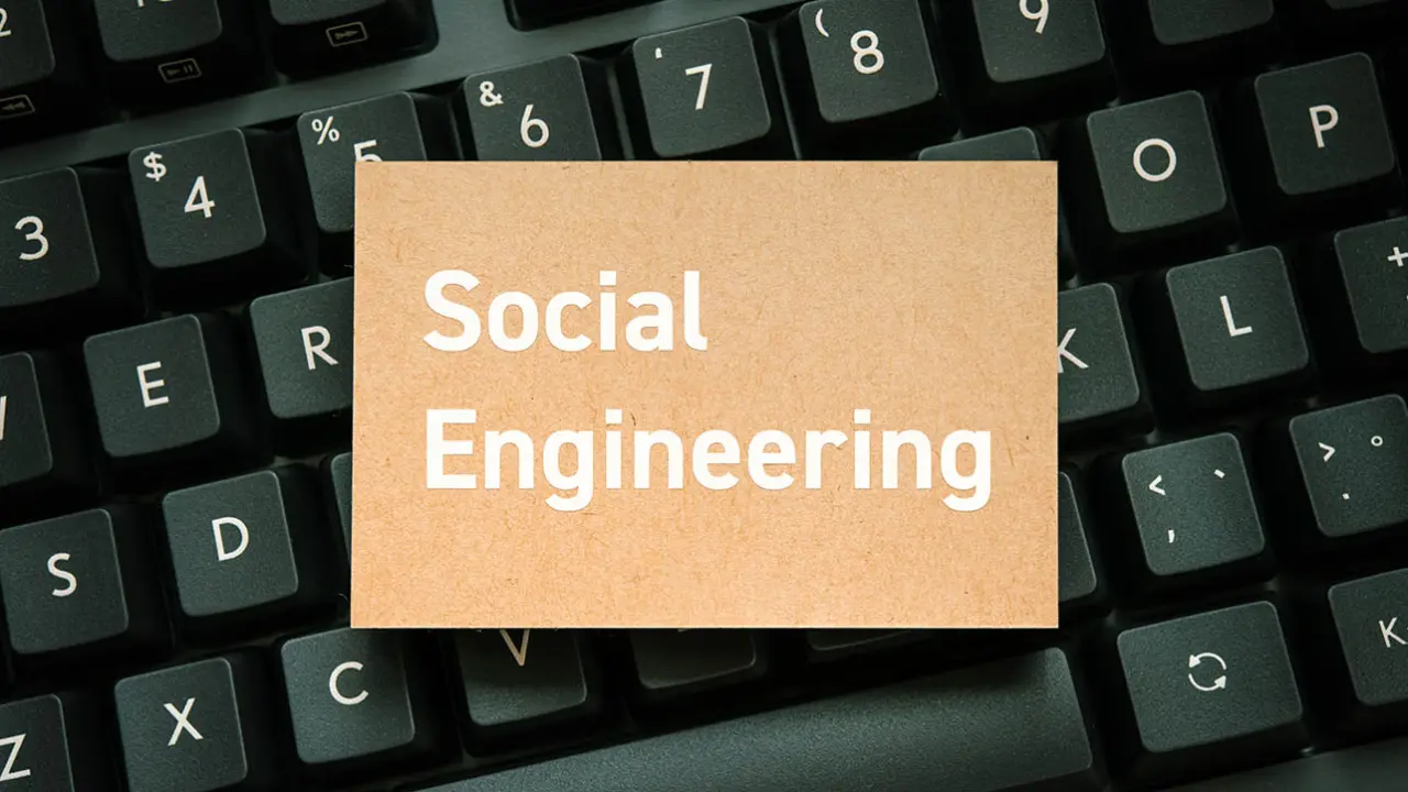 Social engineering cyber threat — growing human hacking attack concept for security awareness article, card on black keyboard